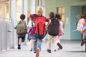 Group of elementary school kids running to school